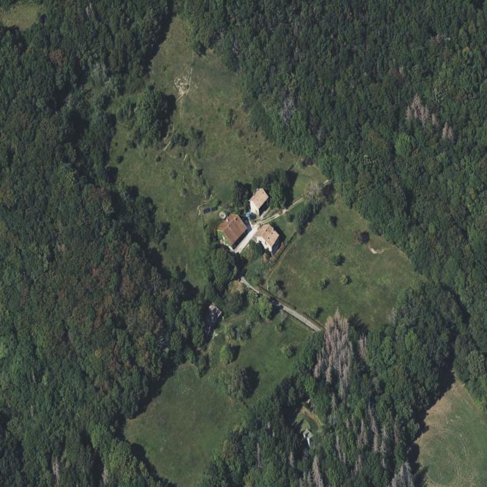 Vue aérienne de la propriété de Sergy avec ses trois maisons au centre de la clairière